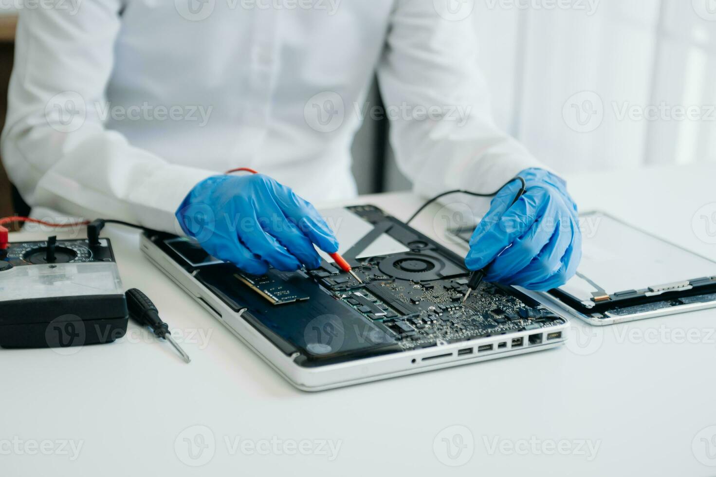 Electronics technician, electronic engineering electronic repair,electronics measuring and testing, repair and maintenance concepts.uses a voltage meter to check and upgrade in shop photo