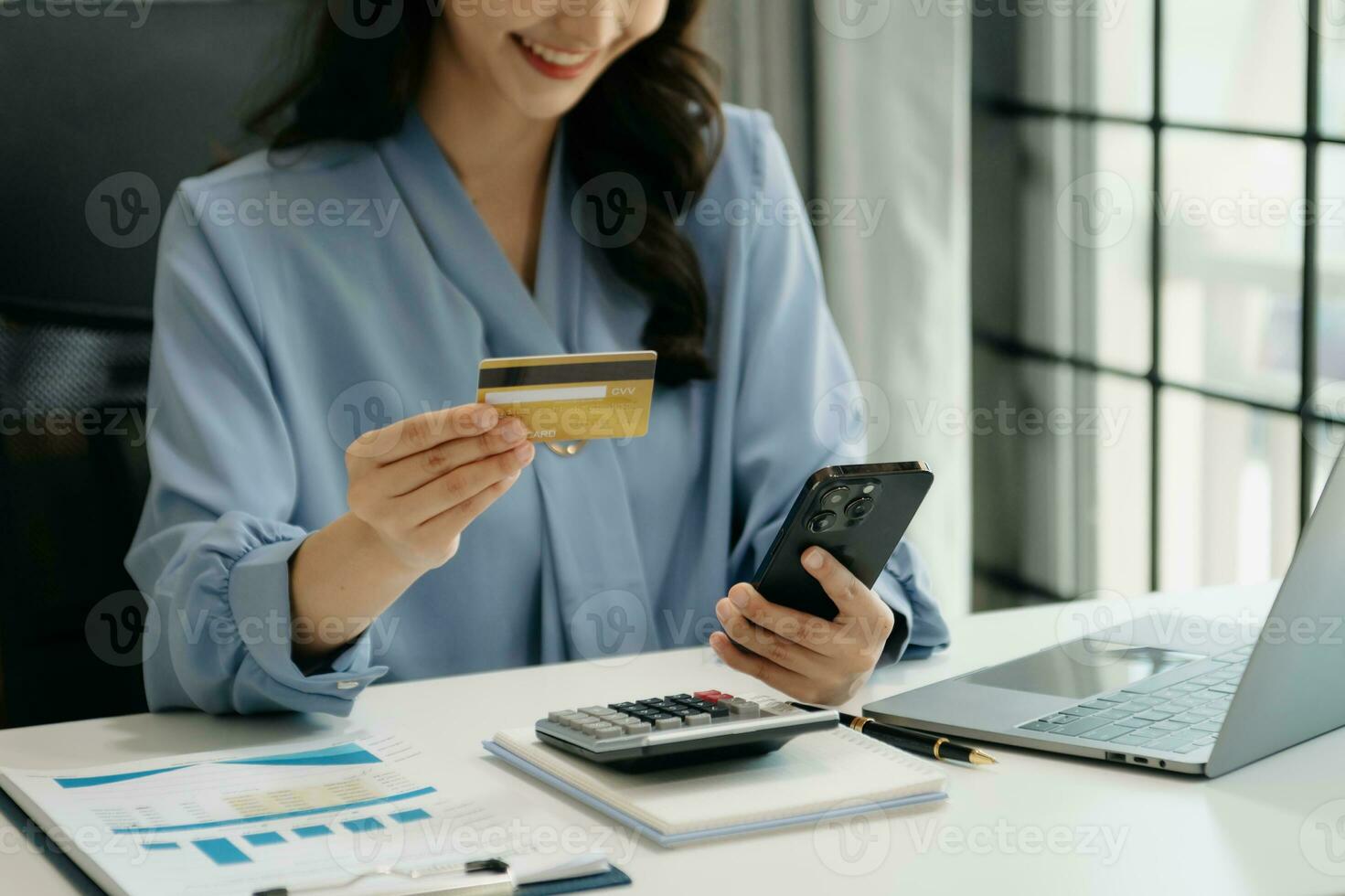 Woman using smart phone for mobile payments online shopping, omni channel, sitting on table, virtual icons graphics interface screen photo