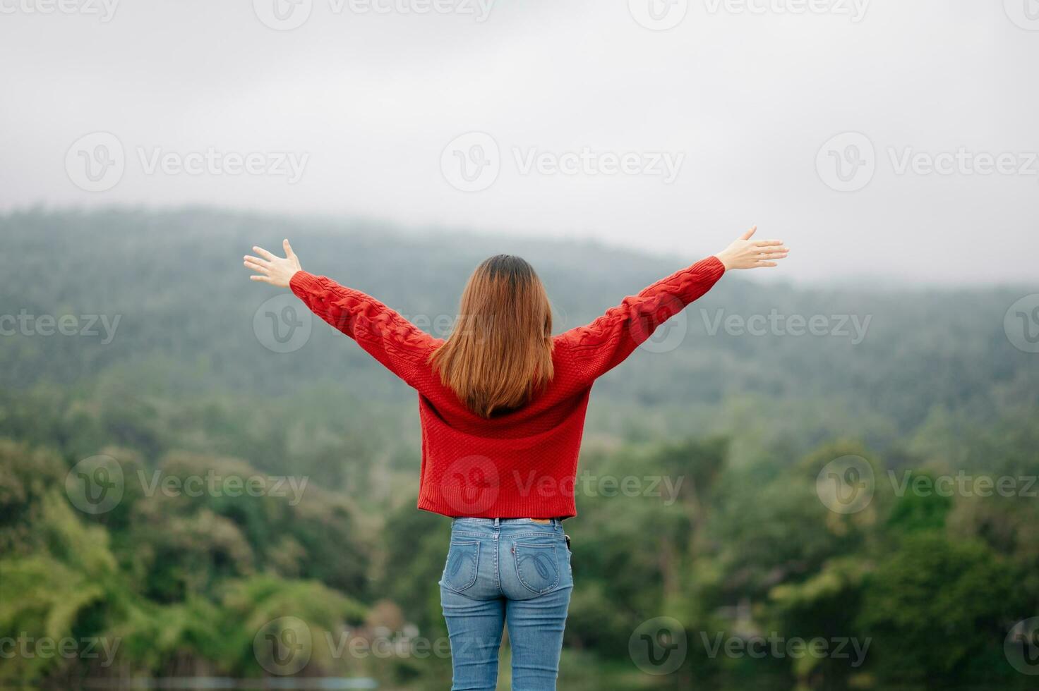 Rear view image of a female traveler sitting and holding breakfast looking at a beautiful mountain, river and nature view photo