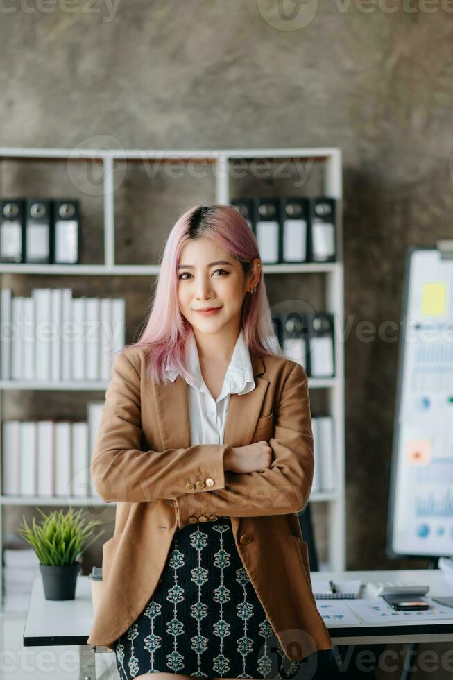 Asian Businesswoman Analyzing Finance on Tablet and Laptop at modern Office Desk tax, report, accounting, statistics, and analytical research concept photo