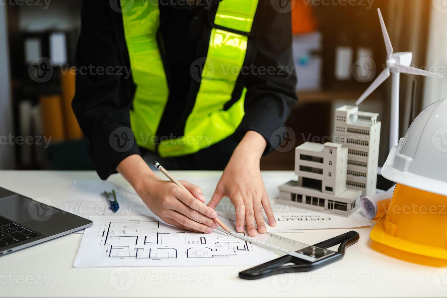 business man hand working and laptop with on on architectural project at construction site at desk in office photo
