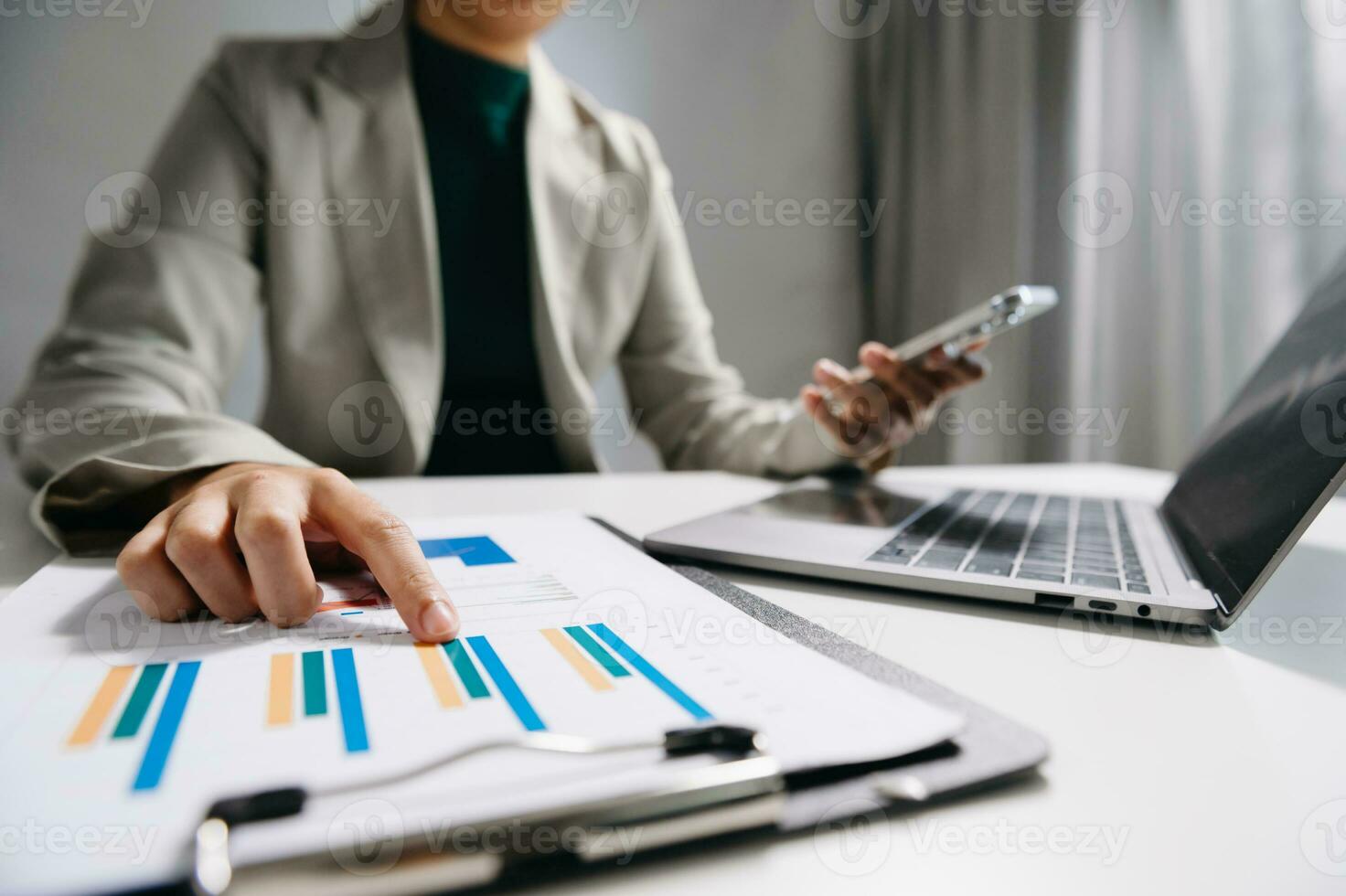 business documents on office desk with laptop and smart phone and graph business diagram and man working at office photo