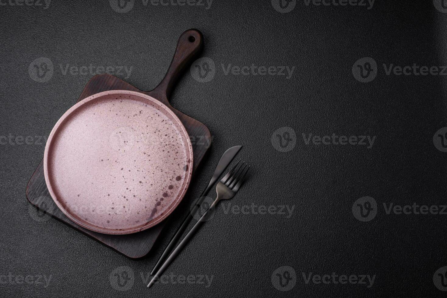 Empty round ceramic plate on a dark textured background photo