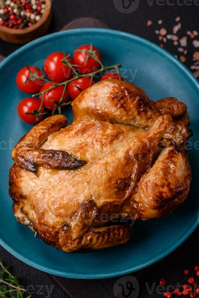 Crispy delicious whole baked chicken with vegetables, salt and spices photo