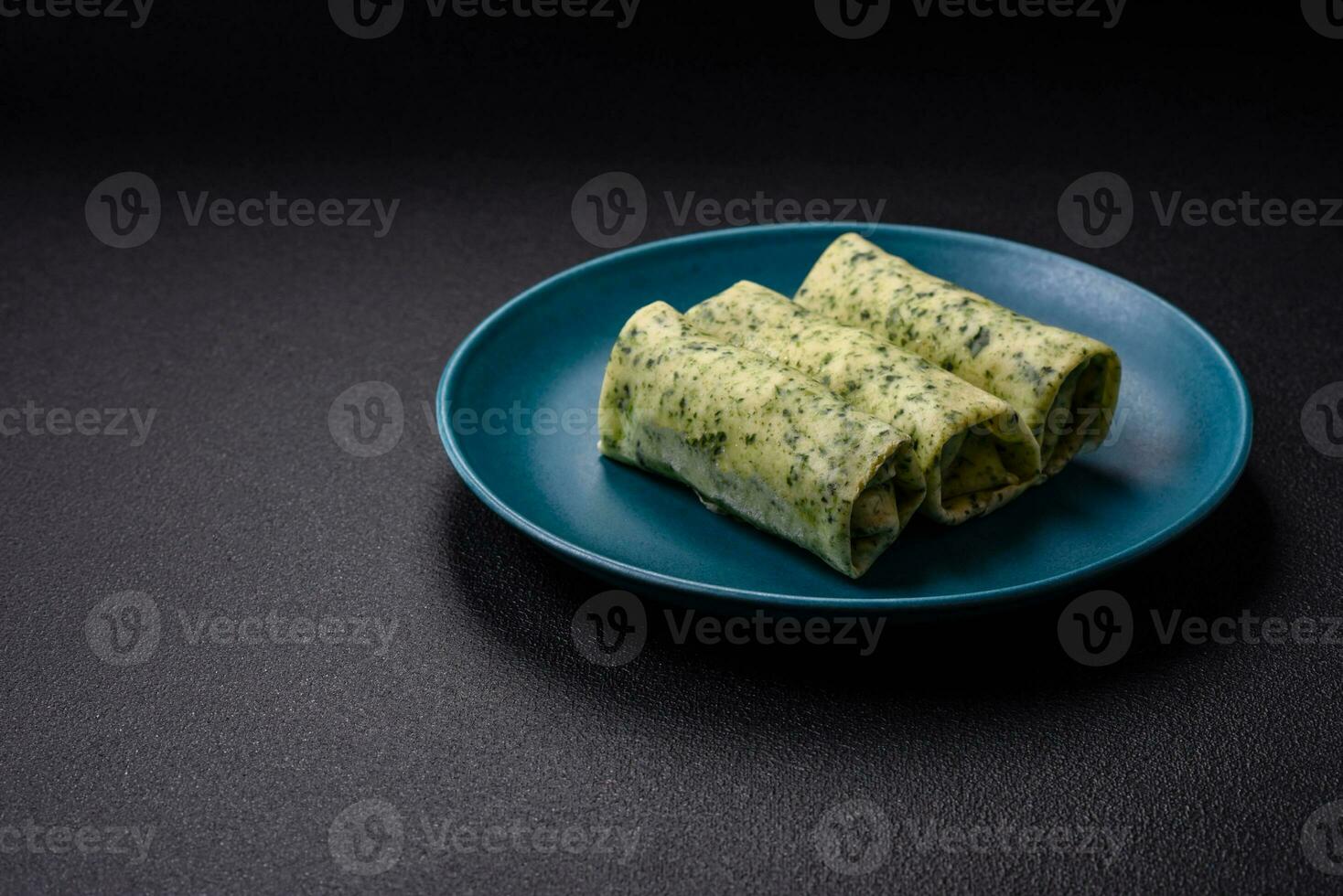 Delicious fresh pancakes with spinach, cream cheese, salmon, salt and spices photo