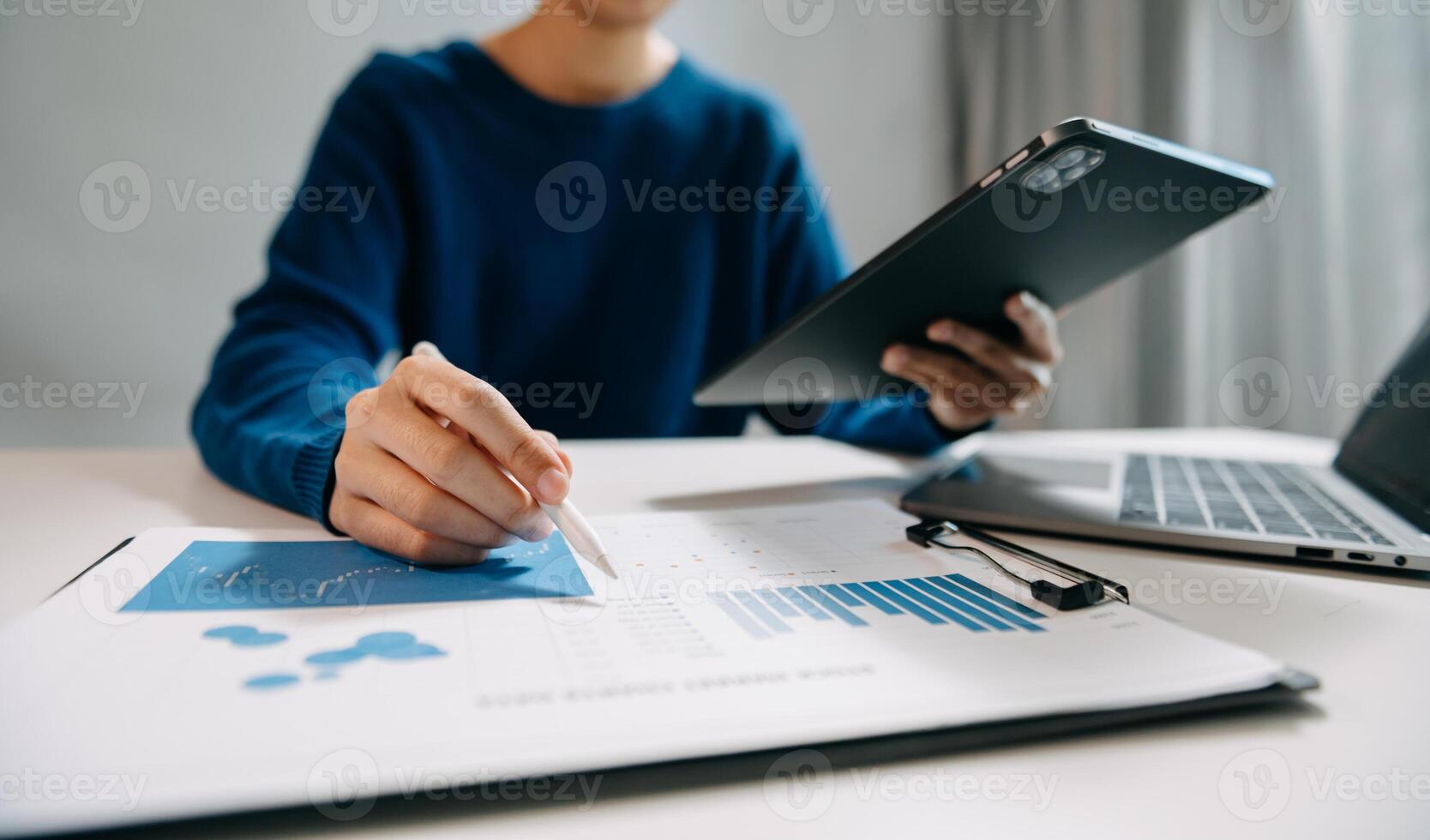 business documents on office desk with laptop and smart phone and graph business diagram and man working at office photo