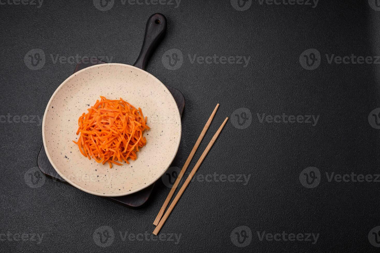 Delicious spicy carrots sliced and cooked in Korean style on a ceramic plate photo