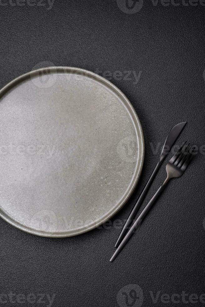 Empty round ceramic plate on a dark textured background photo