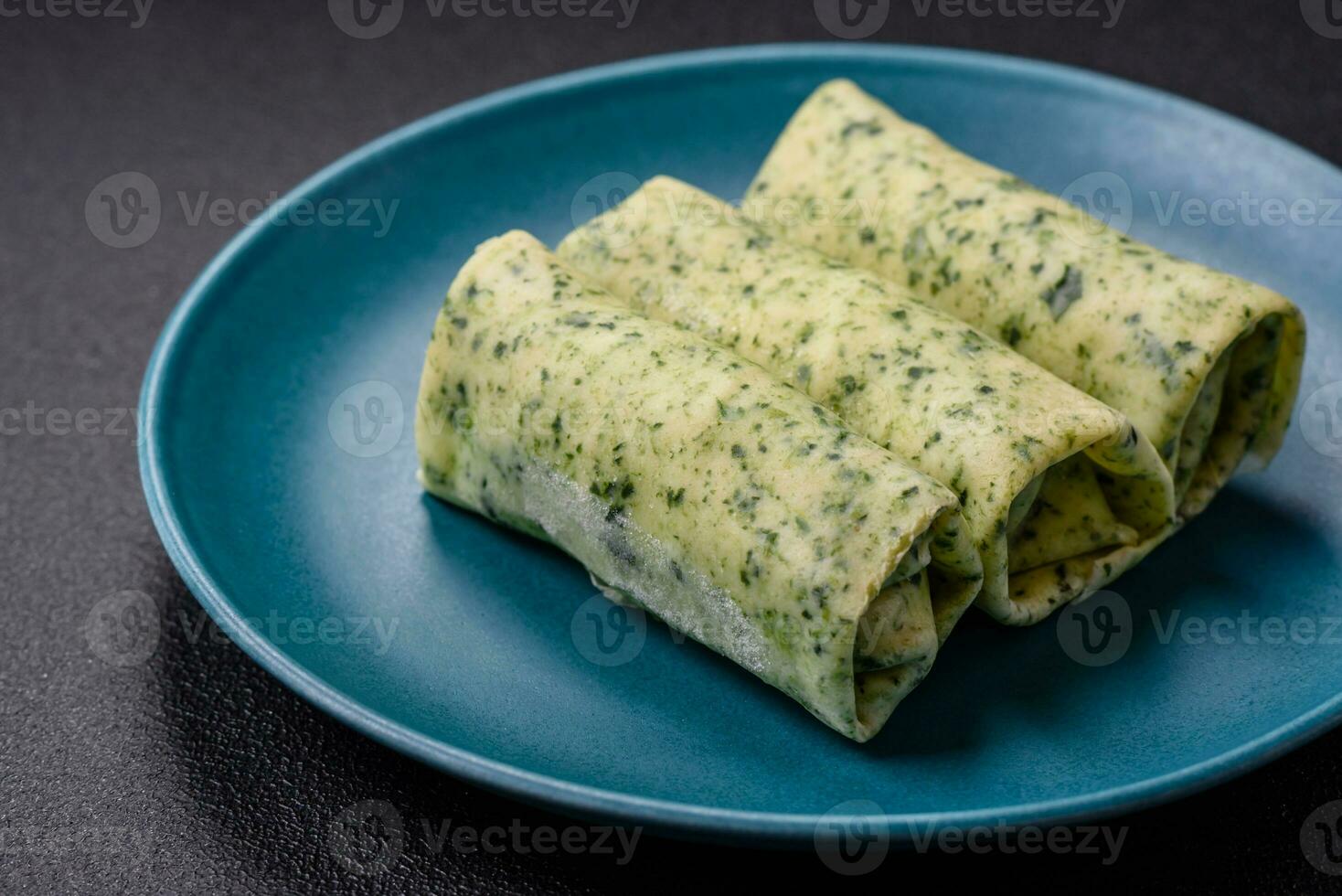 Delicious fresh pancakes with spinach, cream cheese, salmon, salt and spices photo