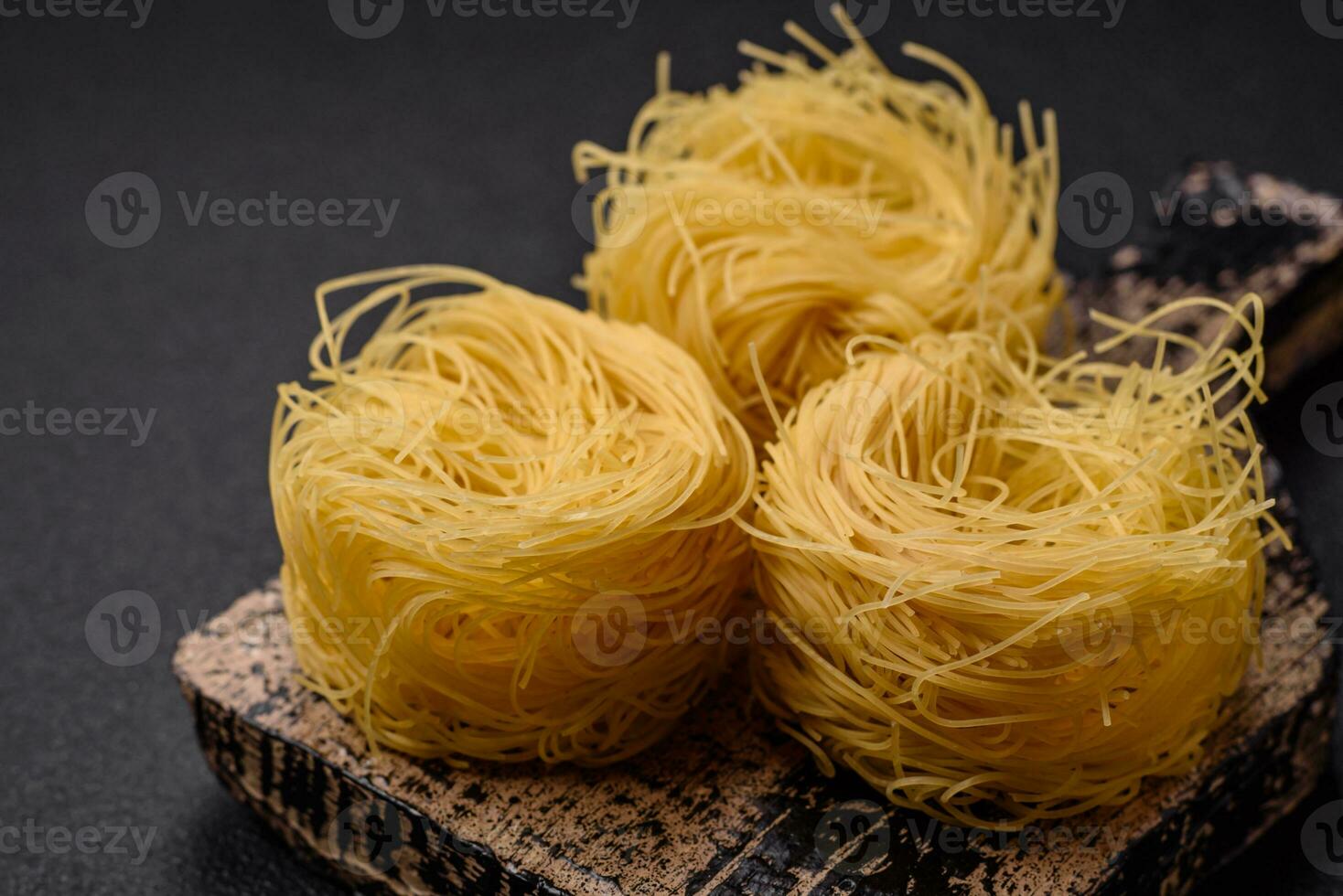 Raw capellini pasta or noodles with salt and spices photo