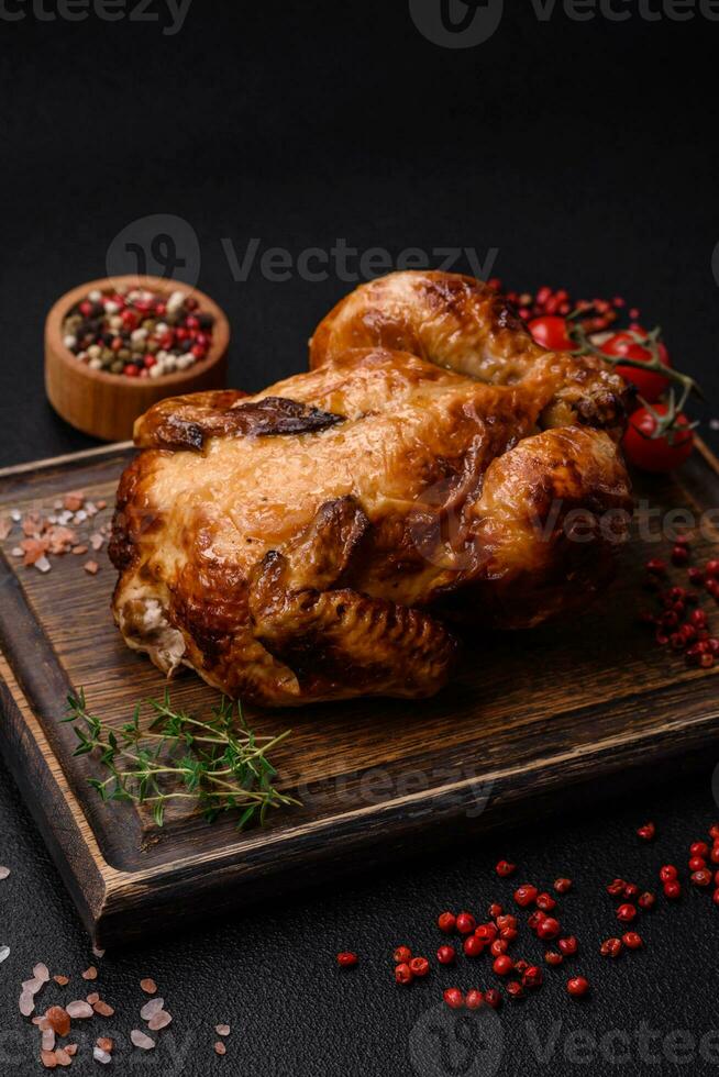 Crispy delicious whole baked chicken with vegetables, salt and spices photo