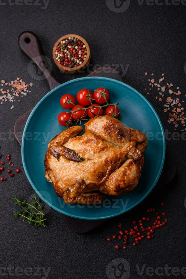 Crispy delicious whole baked chicken with vegetables, salt and spices photo