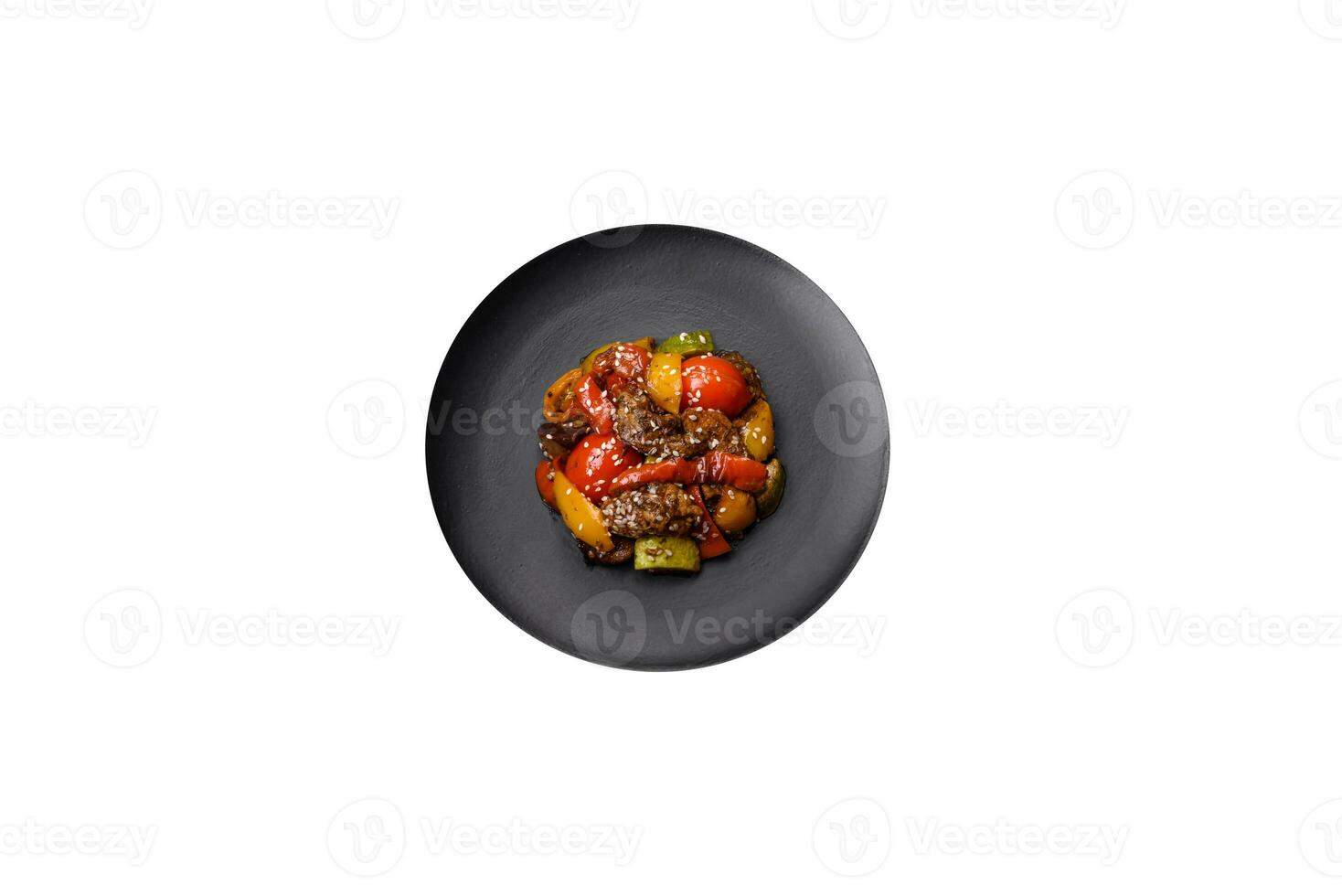 Warm salad with veal, tomatoes, peppers, zucchini, sesame, salt, spices and herbs photo