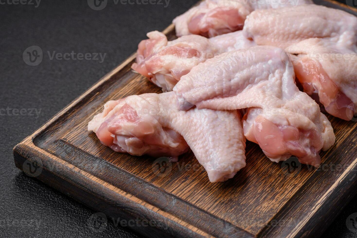 Fresh raw chicken wings with salt and spices prepared for baking photo