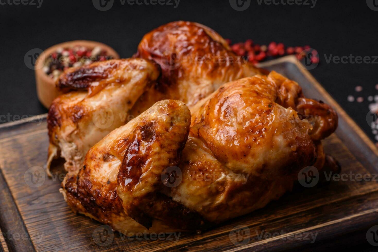 Crispy delicious whole baked chicken with vegetables, salt and spices photo