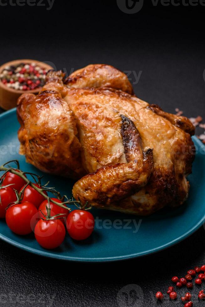 Crispy delicious whole baked chicken with vegetables, salt and spices photo