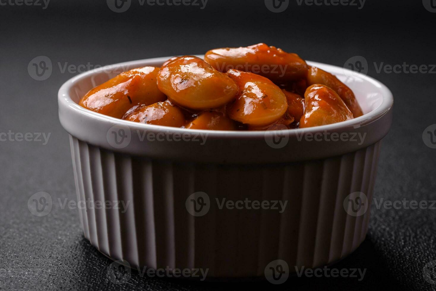 Delicious canned beans in a tomato in a round ceramic plate photo