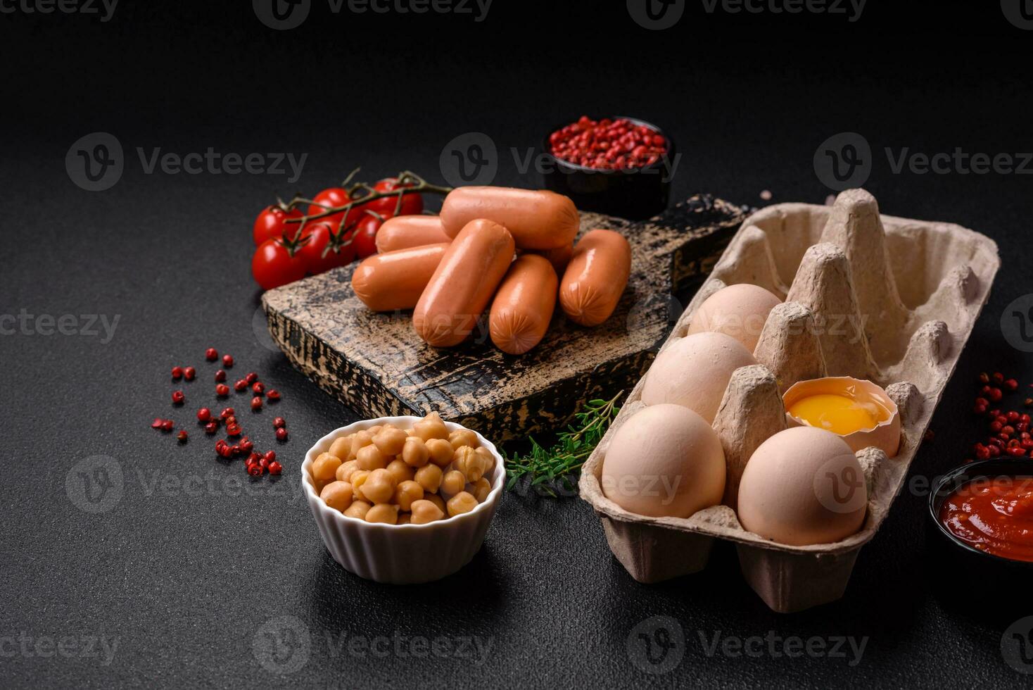 crudo pollo huevos en un caja, Cereza Tomates, garbanzos, especias, sal y hierbas foto