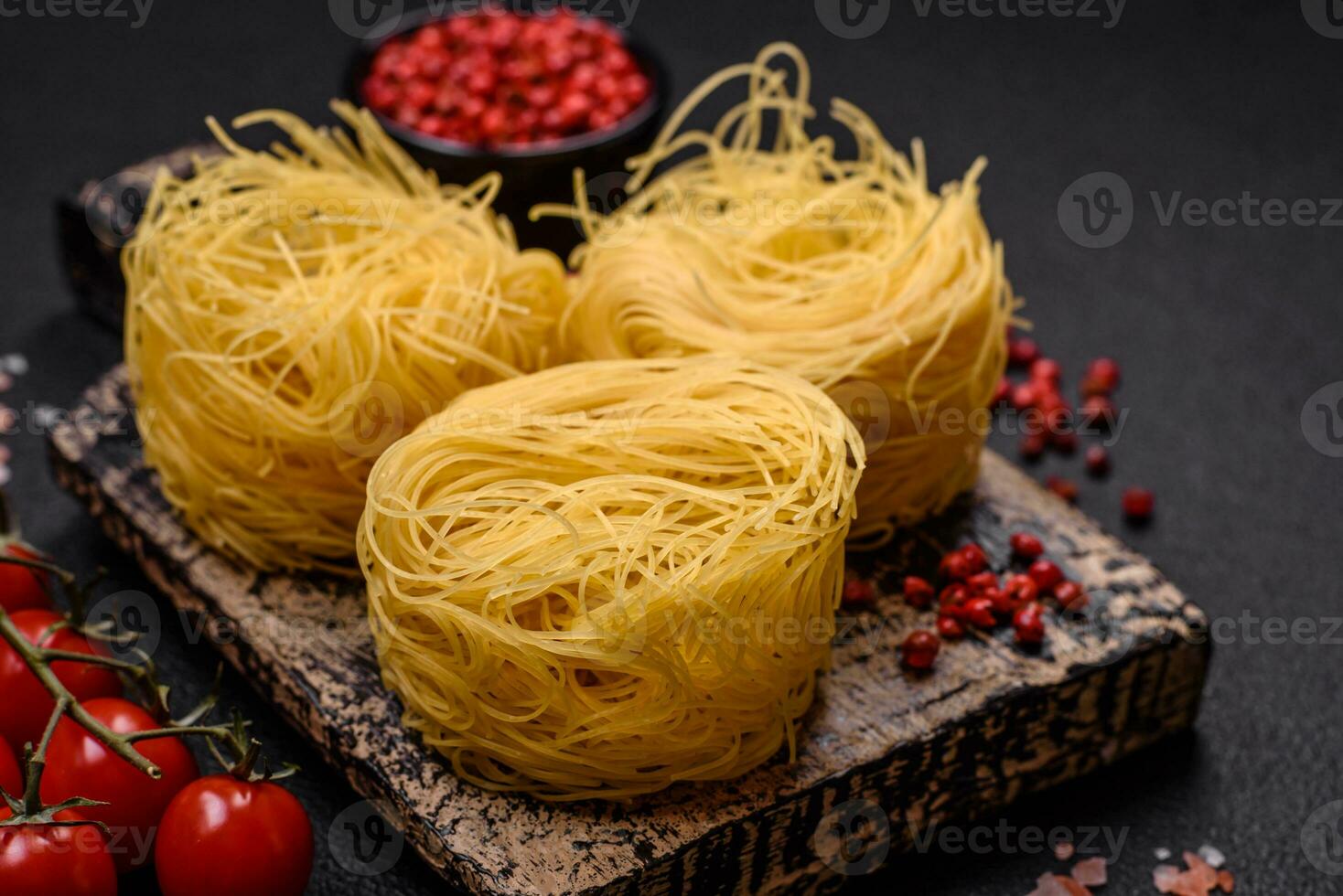 Raw capellini pasta or noodles with salt and spices photo