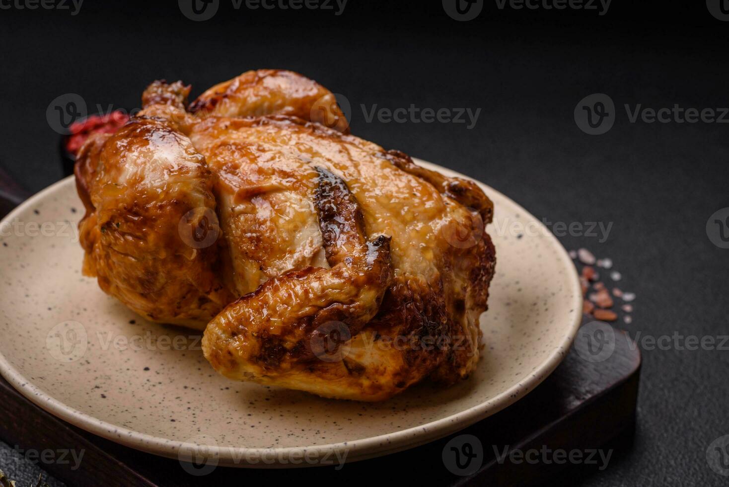 Crispy delicious whole baked chicken with vegetables, salt and spices photo