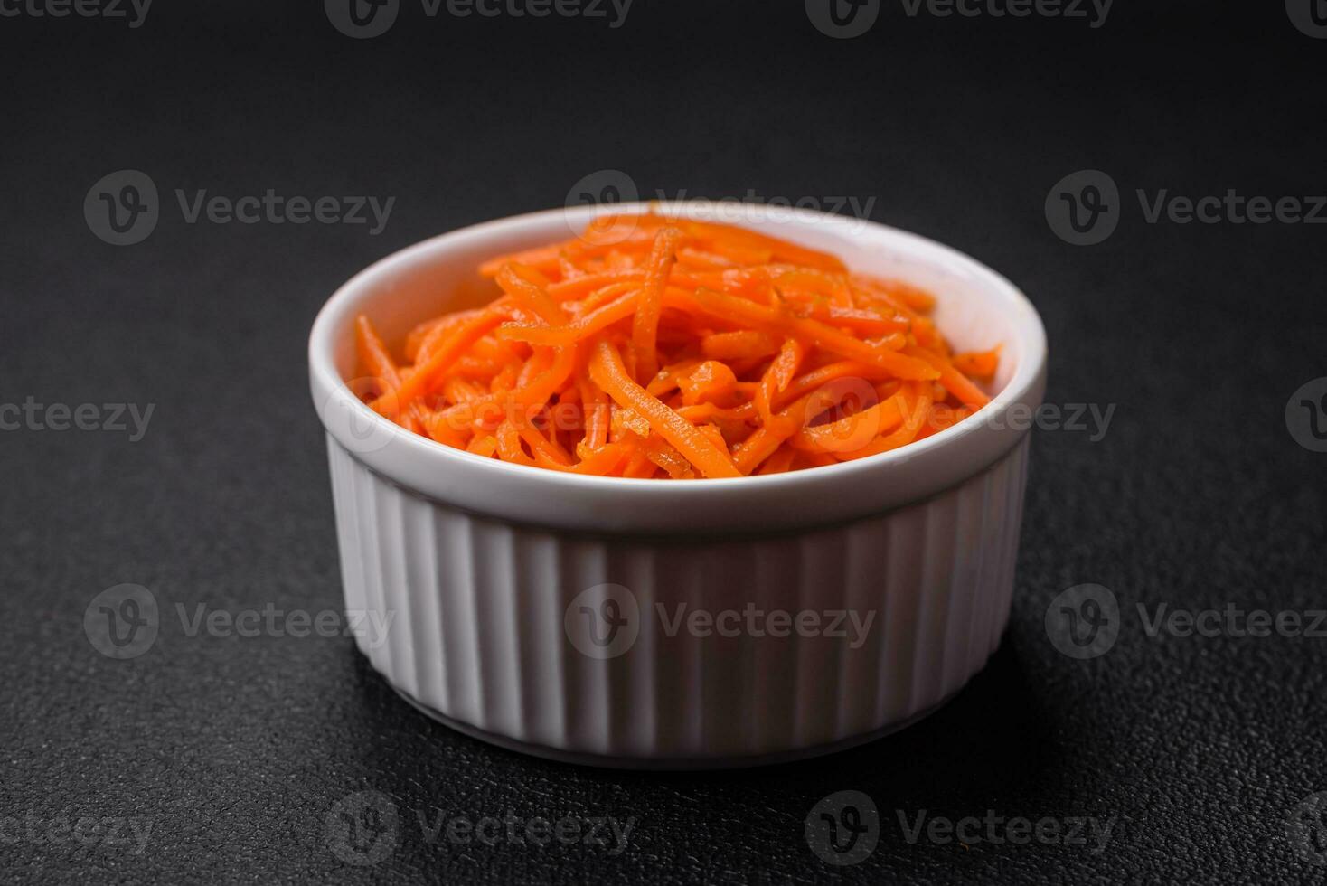 Delicious spicy carrots sliced and cooked in Korean style on a ceramic plate photo
