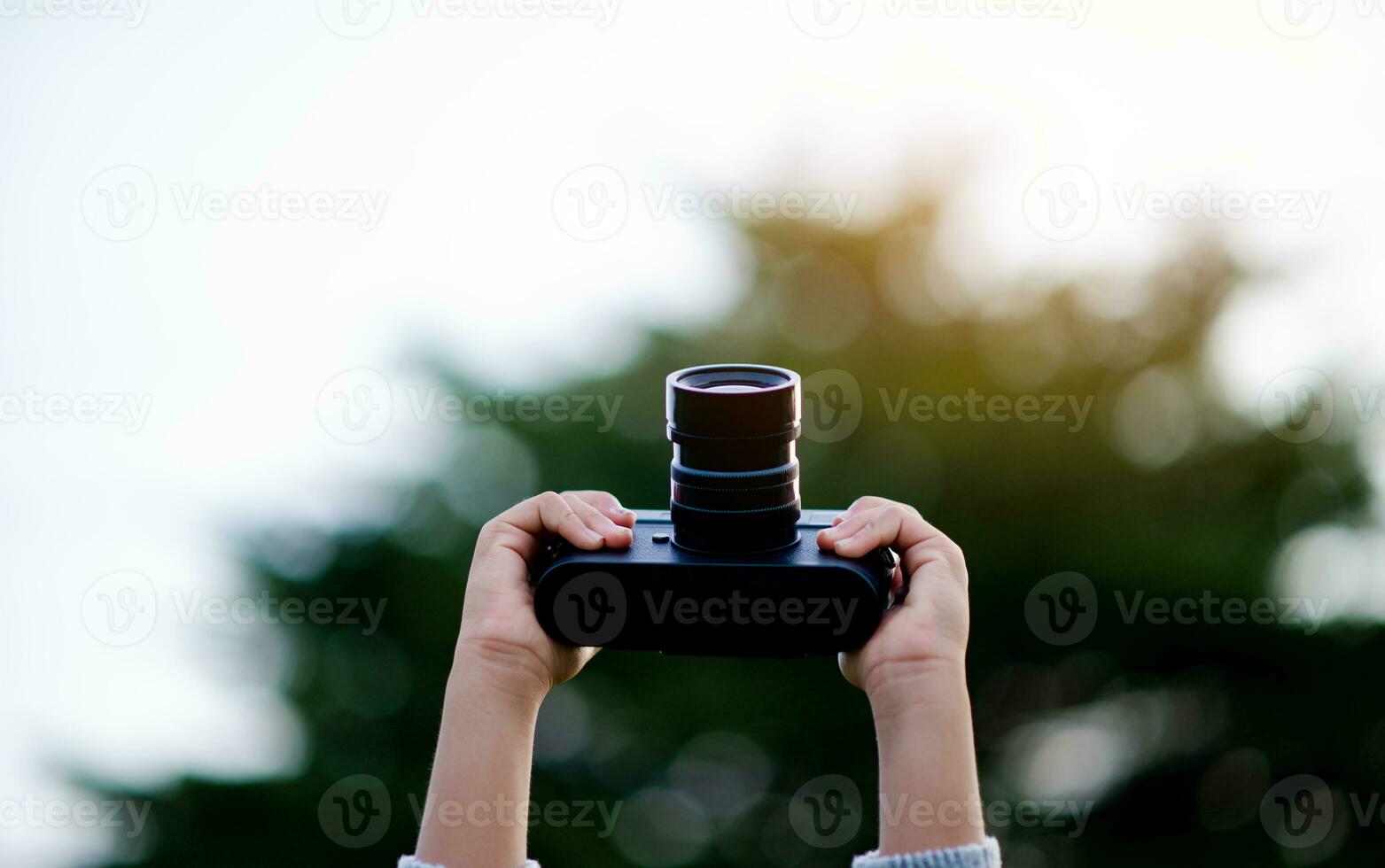 Take pictures with a mirrorless camera. Little girl practicing nature photography little photographer the joy of taking pictures photo
