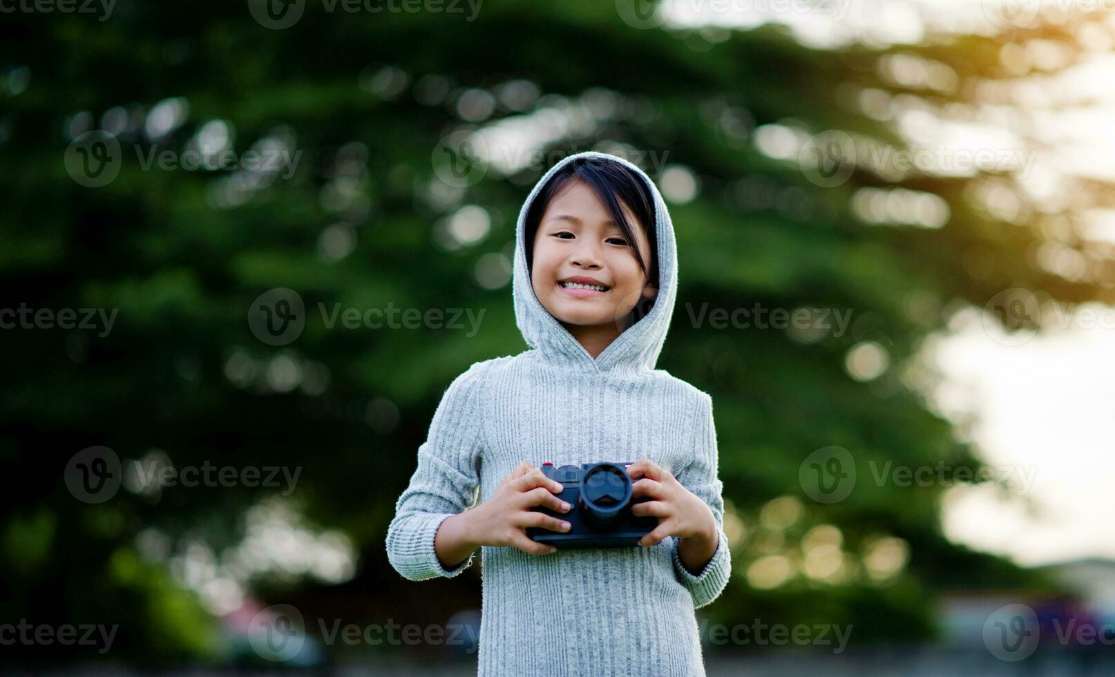 Take pictures with a mirrorless camera. Little girl practicing nature photography little photographer the joy of taking pictures photo