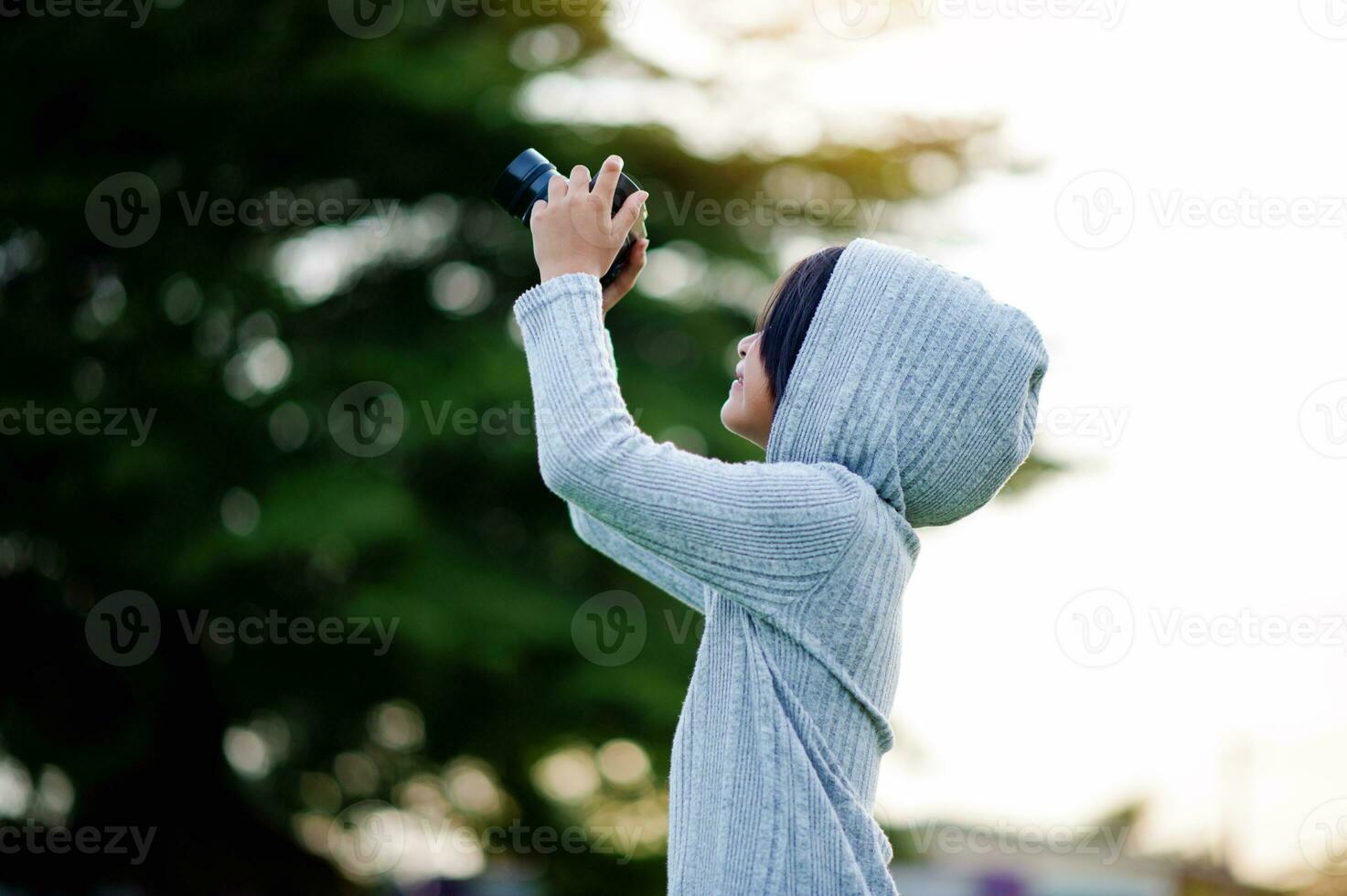 Take pictures with a mirrorless camera. Little girl practicing nature photography little photographer the joy of taking pictures photo
