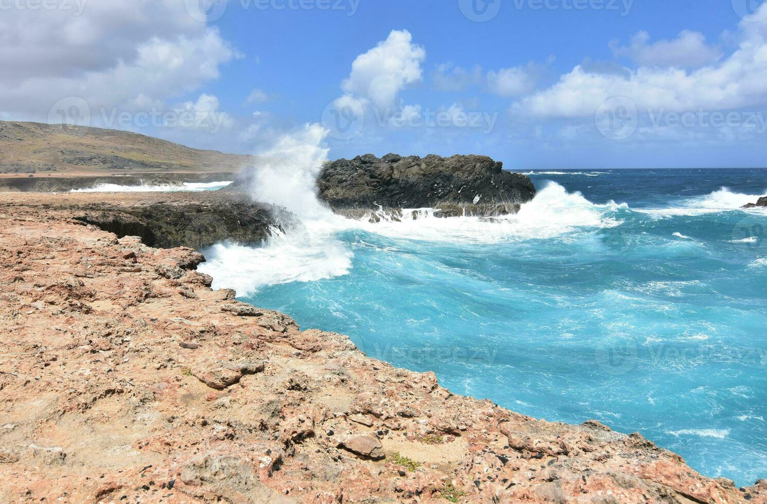 Large Waves Splashing Against the Rock Cliffs in Aruba photo