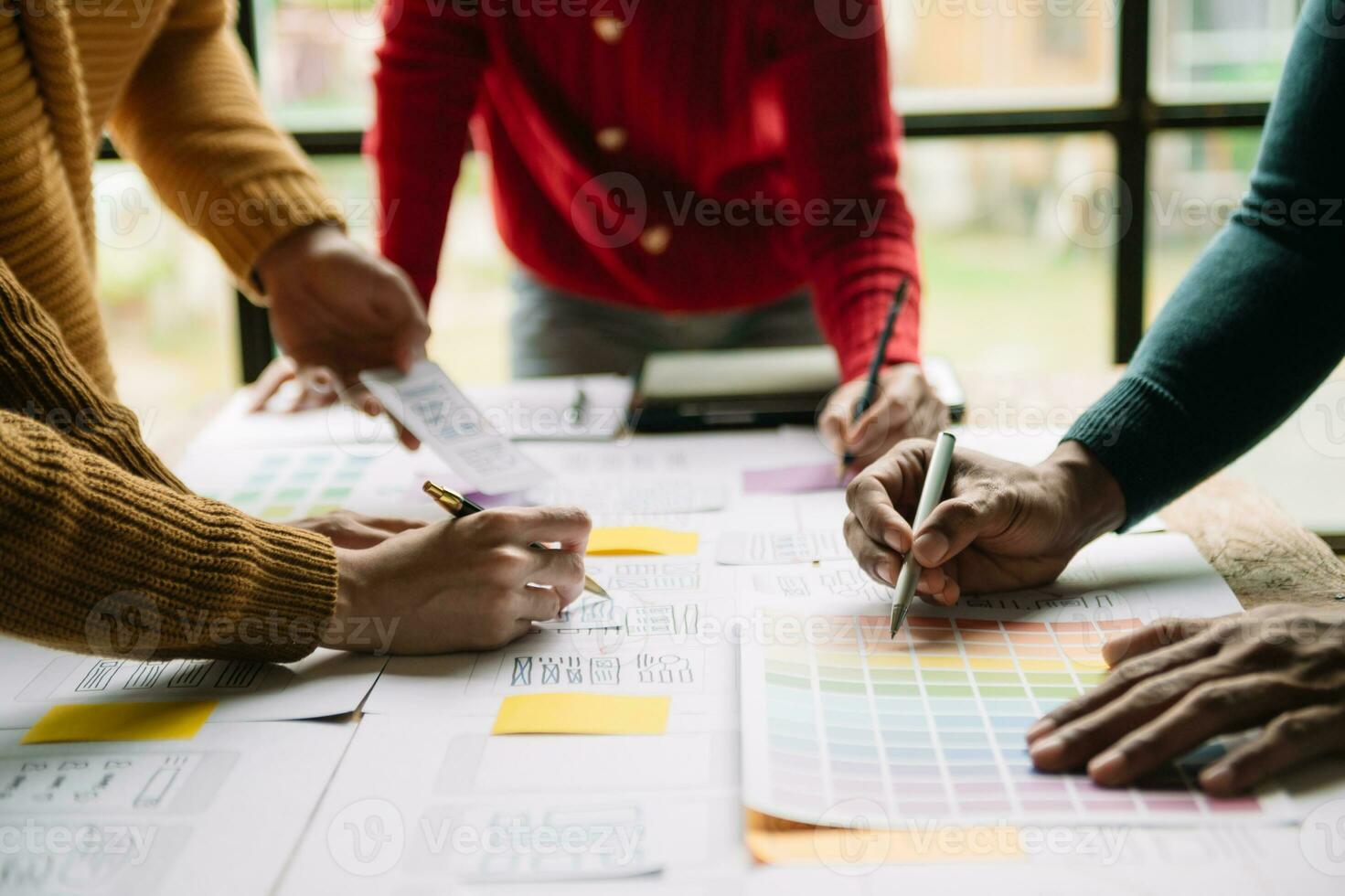 UX developer and ui designer brainstorming about mobile app interface wireframe design with customer breif and color code at modern office. photo