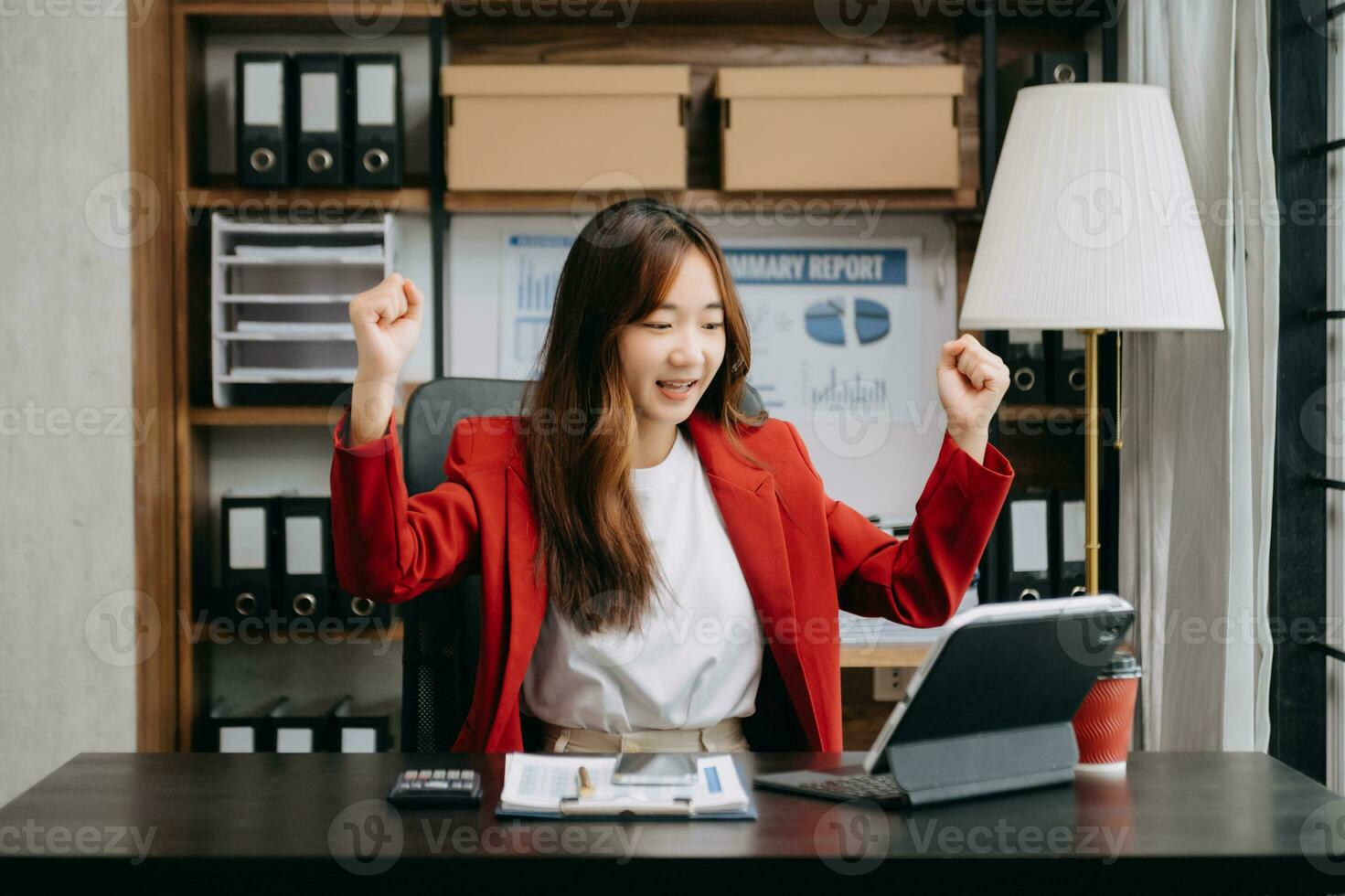 Asian business woman are delighted and happy with the work they do on their tablet, laptop and taking notes at the office. photo