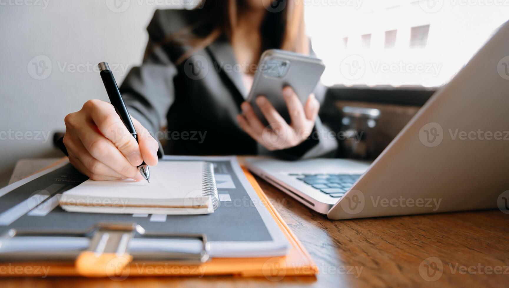 business documents on office desk with laptop and smart phone and graph business diagram and man working in morning light photo