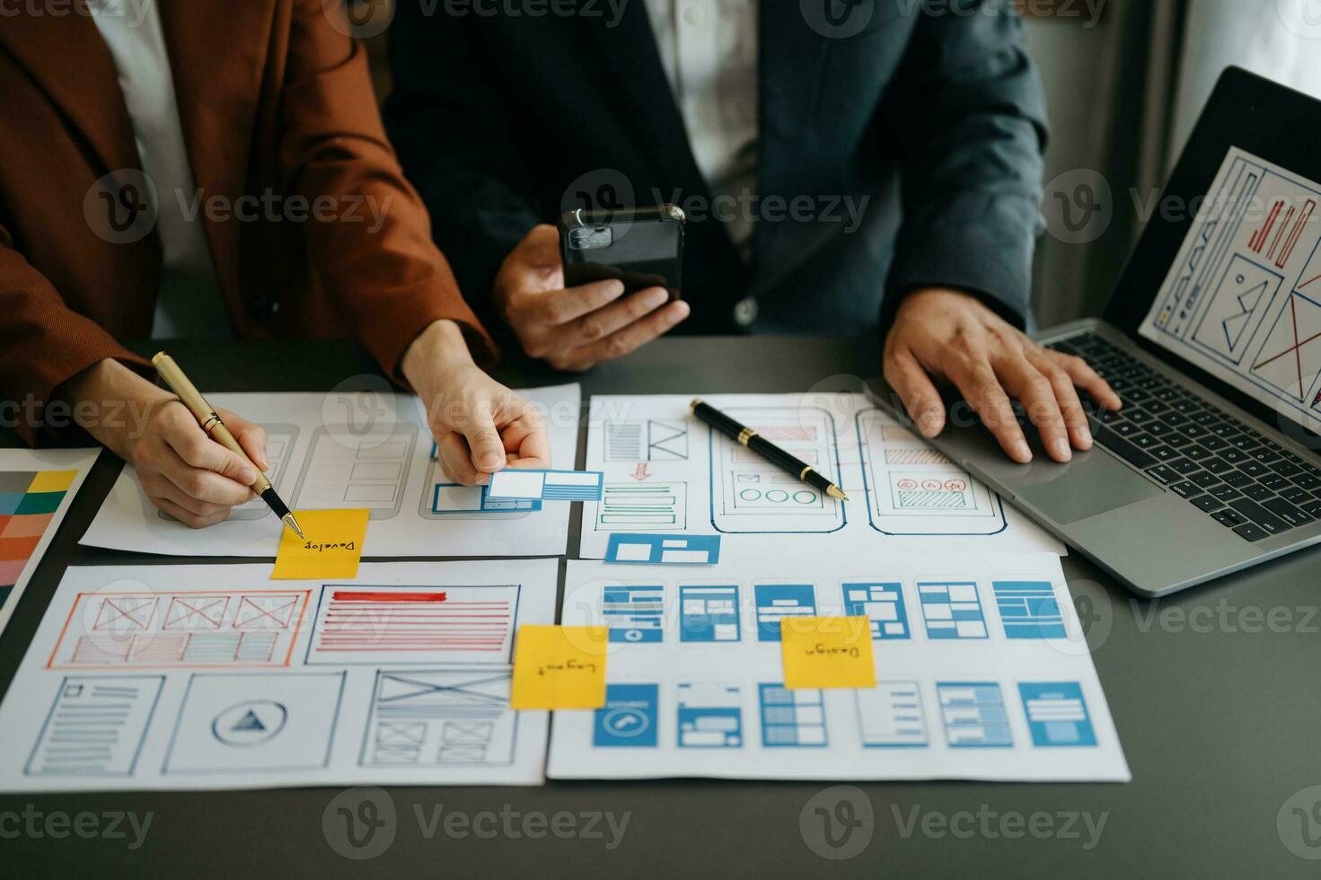 UX developer and ui designer brainstorming about mobile app interface wireframe design with customer breif and color code at office. photo
