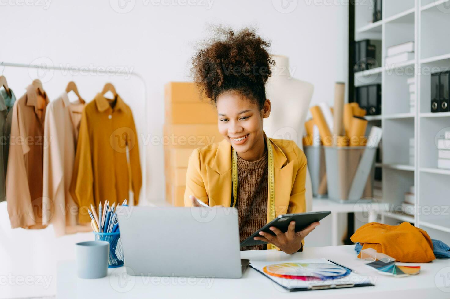 africano Sastre mujer trabajando en ropa en sastrería taller. hermosa joven hembra Moda diseñador sonrisa y después éxito en estudio foto