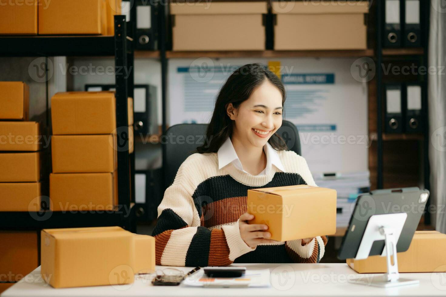 Beautiful Asian lady blogger showing clothes in front of the camera to recording vlog video live streaming photo