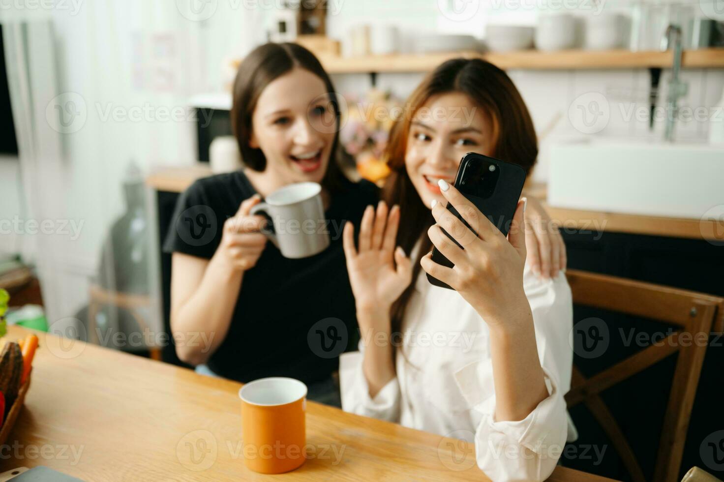 Two  students learning together online with a laptop, tablet and tutor together in the kitchen or living room at home. photo