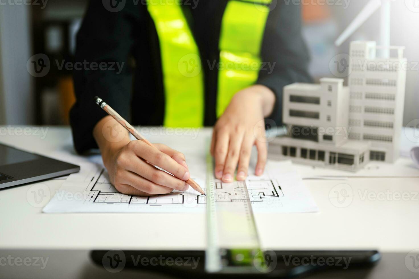 Creative architect projecting on the big drawings with architectural project at construction site at desk in office photo
