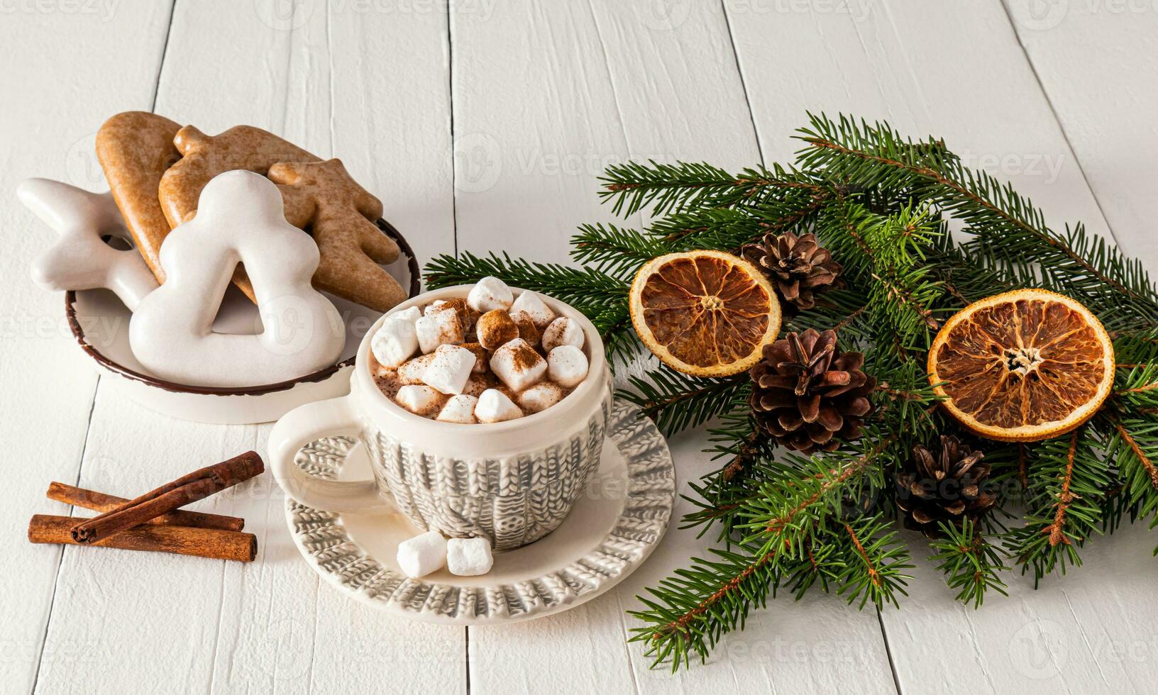 Beautiful knitted pattern cup with hot cocoa and marshmallow, handmade gingerbread plate on white wooden table. Christmas traditional drink. photo