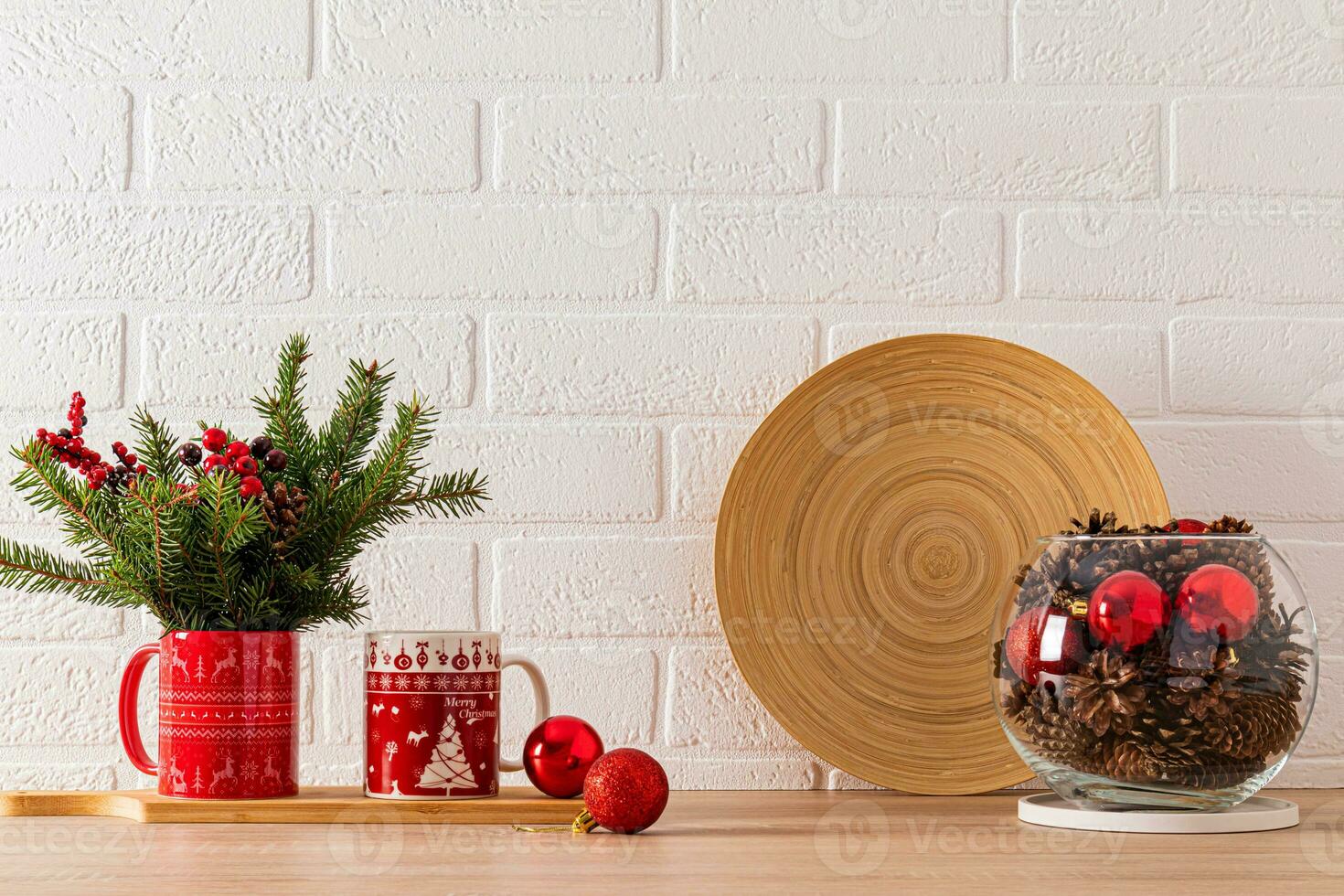 dos tazas con un Navidad modelo en el cocina encimera con abeto ramas y un redondo vaso florero con conos y rojo pelotas. frente vista. foto