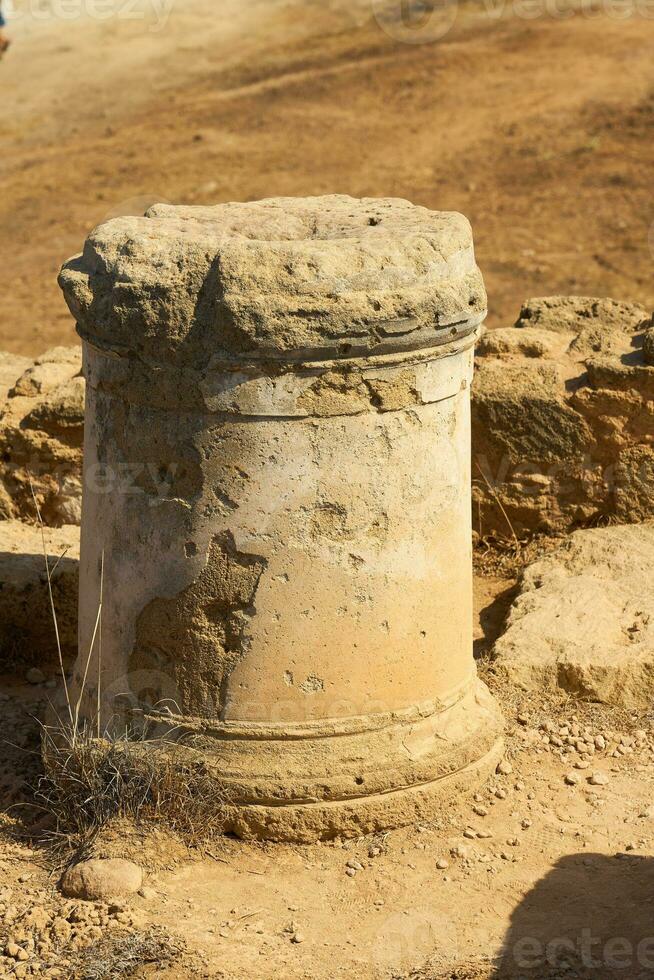 An ancient stone column up close with a blurred background. photo