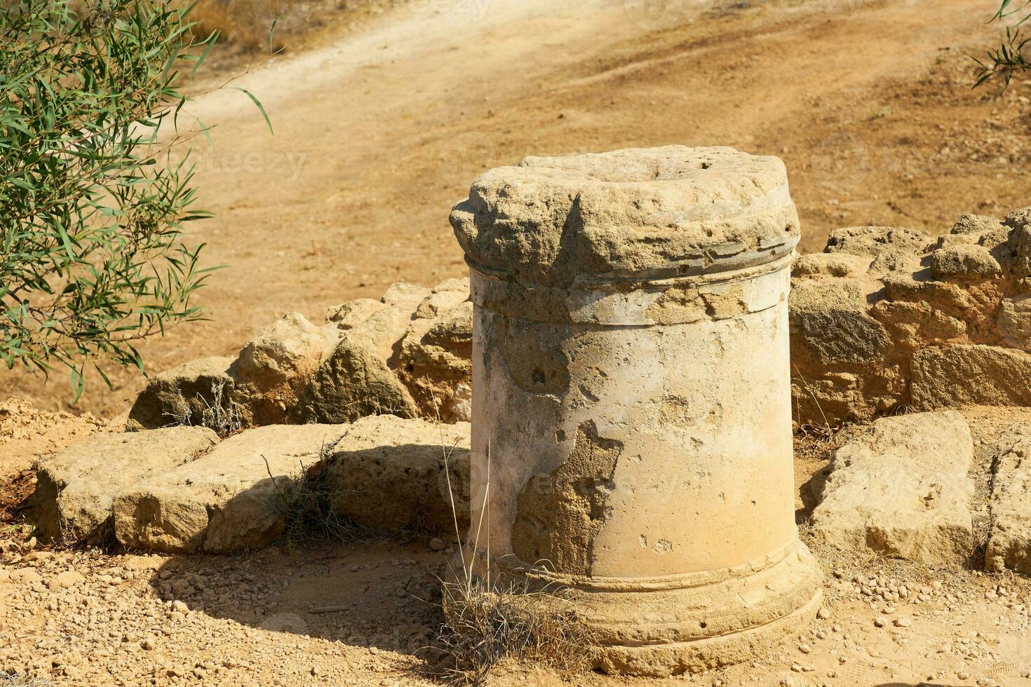 An ancient stone column up close with a blurred background. photo