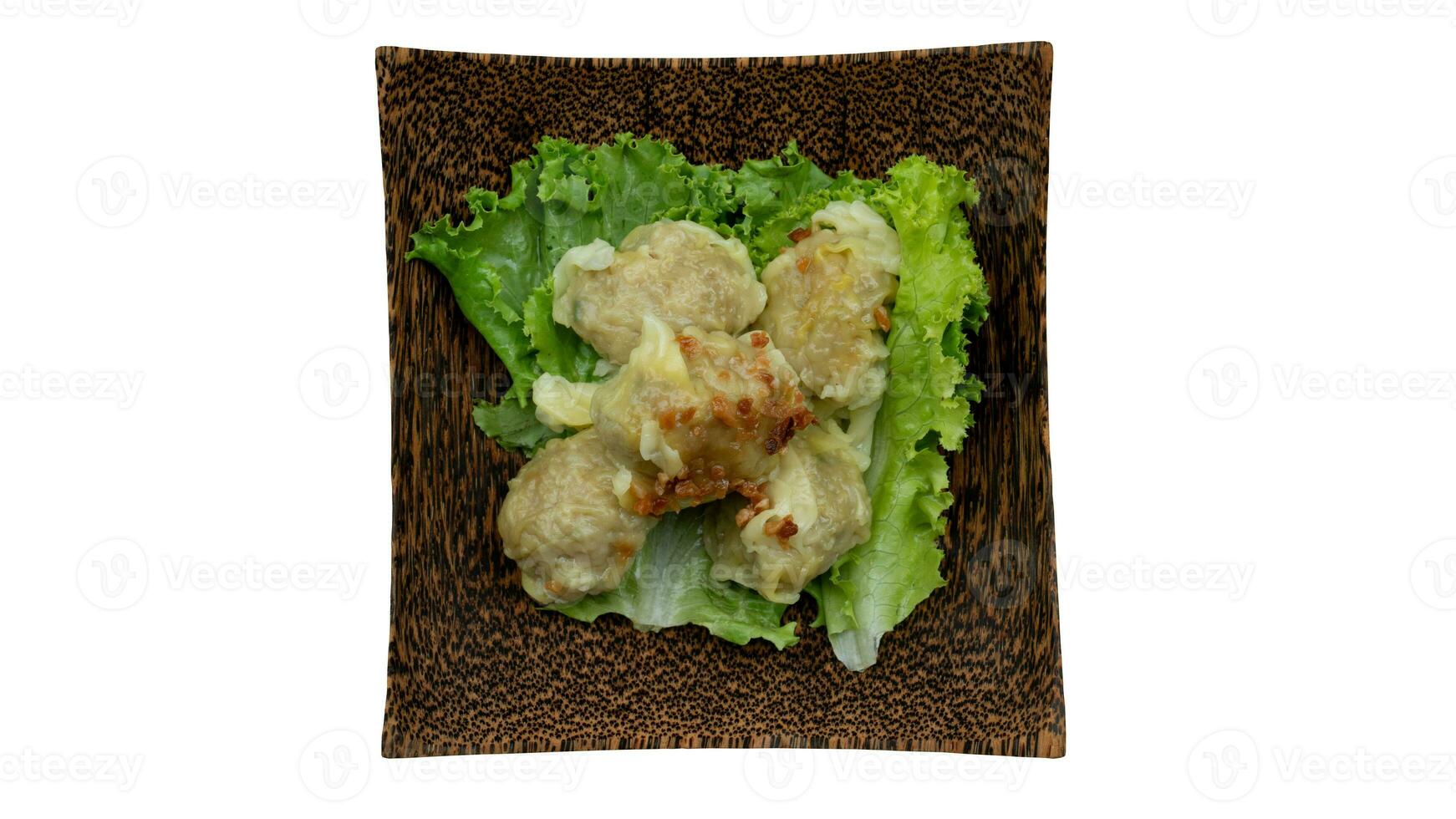 Thailand food appetizers menu of Pork dumplings wrapped in yellow dumplings. Arrange on top of Lettuce or Epicurious. Served on a coconut plate. Isolated white background. with clipping path. photo