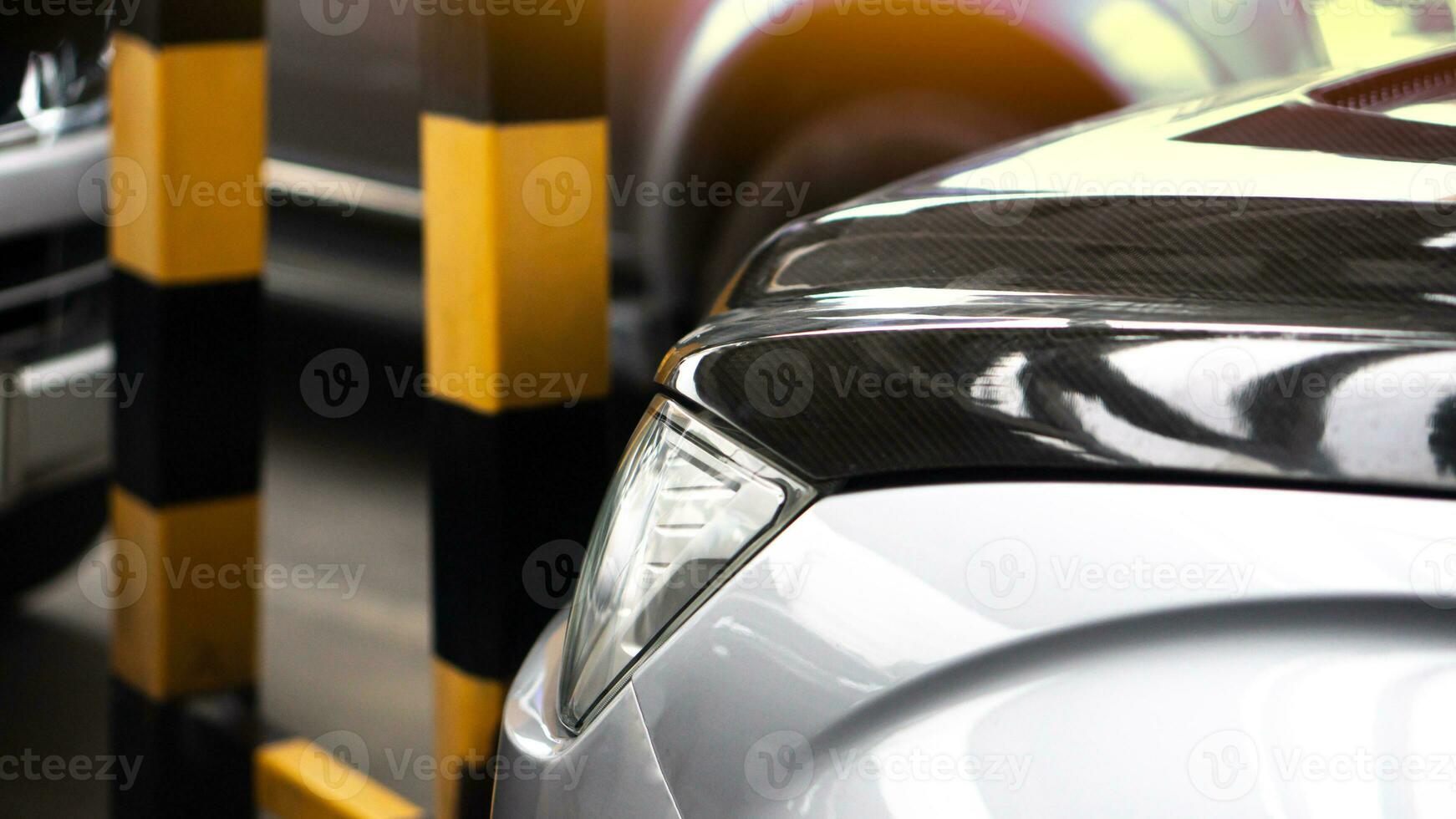 Abstract view front of car hood in the parking lot. with blurred of other cars pakring indoor of parking lot. photo