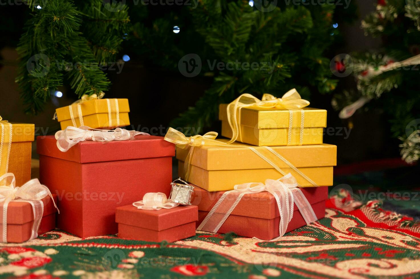 Gift boxes with ribbons under the Christmas tree on the carpet photo