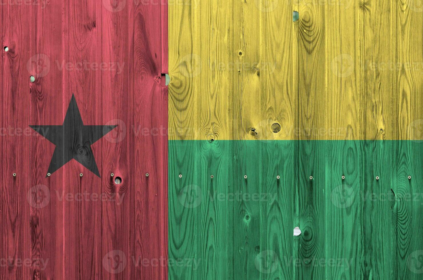 Guinea Bissau flag depicted in bright paint colors on old wooden wall. Textured banner on rough background photo