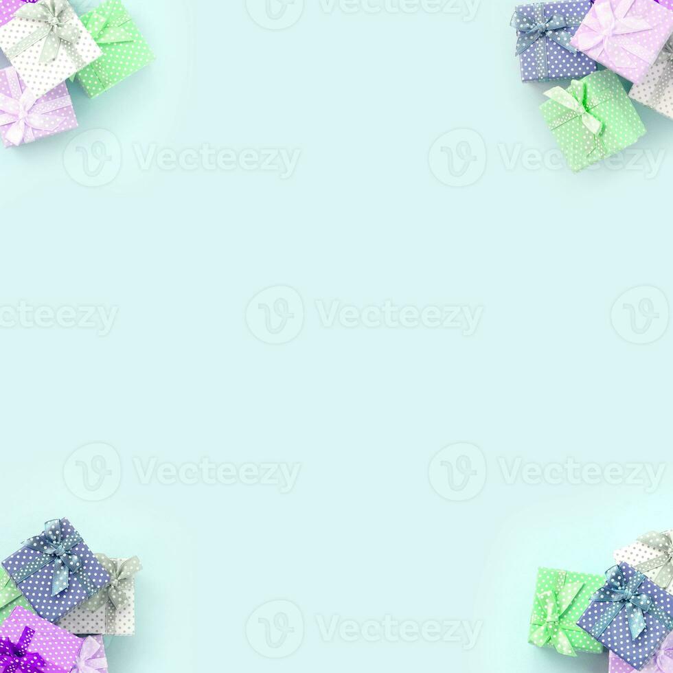 Piles of a small colored gift boxes with ribbons lies on a violet background. Minimalism flat lay top view pattern photo