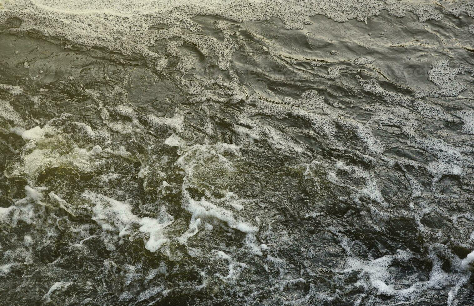 Waves of water of the river and the sea meet each other during high tide and low tide. Deep blue stormy sea water surface with white foam and waves pattern, background photo