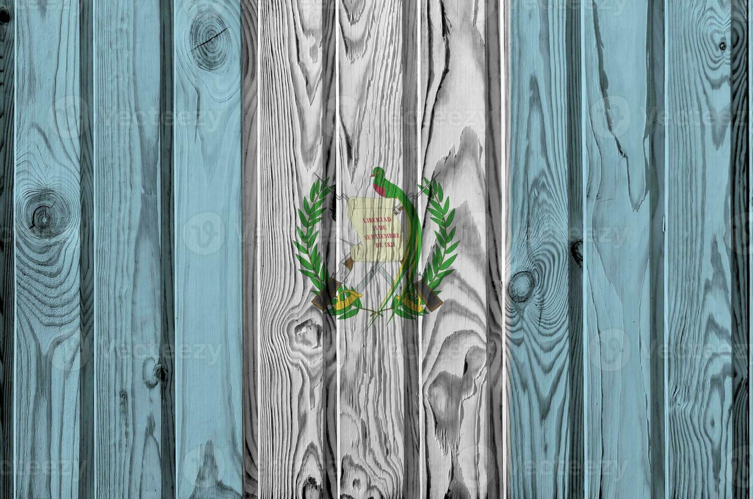 Guatemala flag depicted in bright paint colors on old wooden wall. Textured banner on rough background photo