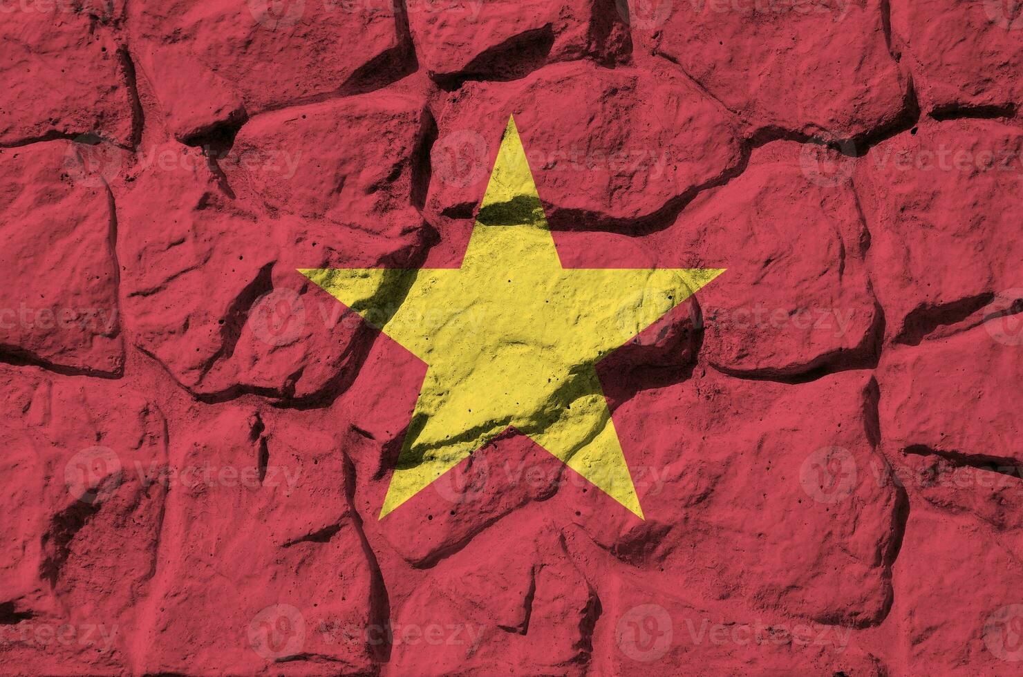 Vietnam flag depicted in paint colors on old stone wall closeup. Textured banner on rock wall background photo