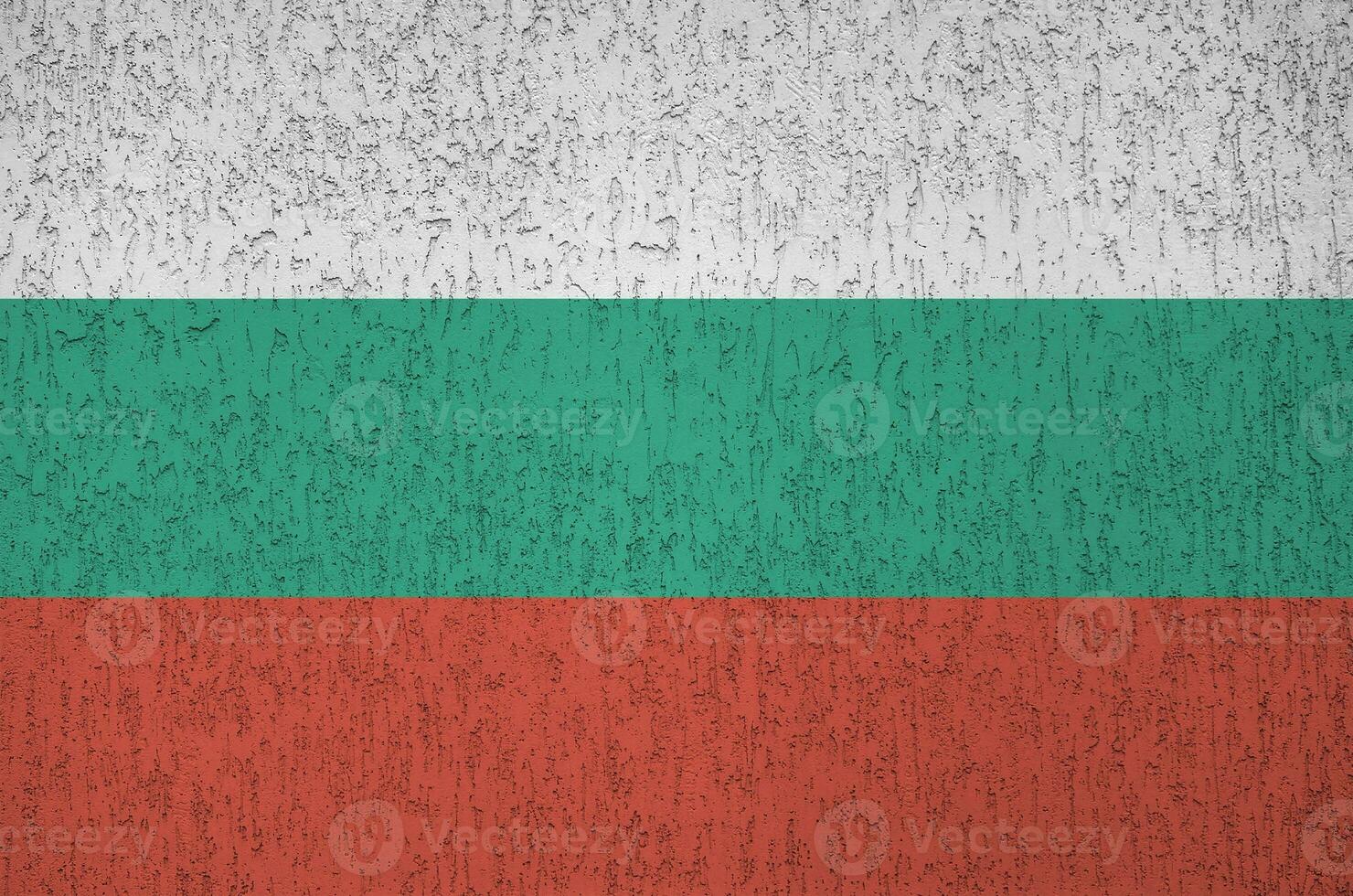 Bulgaria flag depicted in bright paint colors on old relief plastering wall. Textured banner on rough background photo